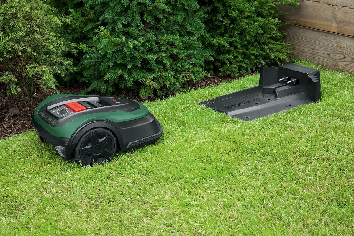 Bosch Indego S 500 next to the charging station in the garden