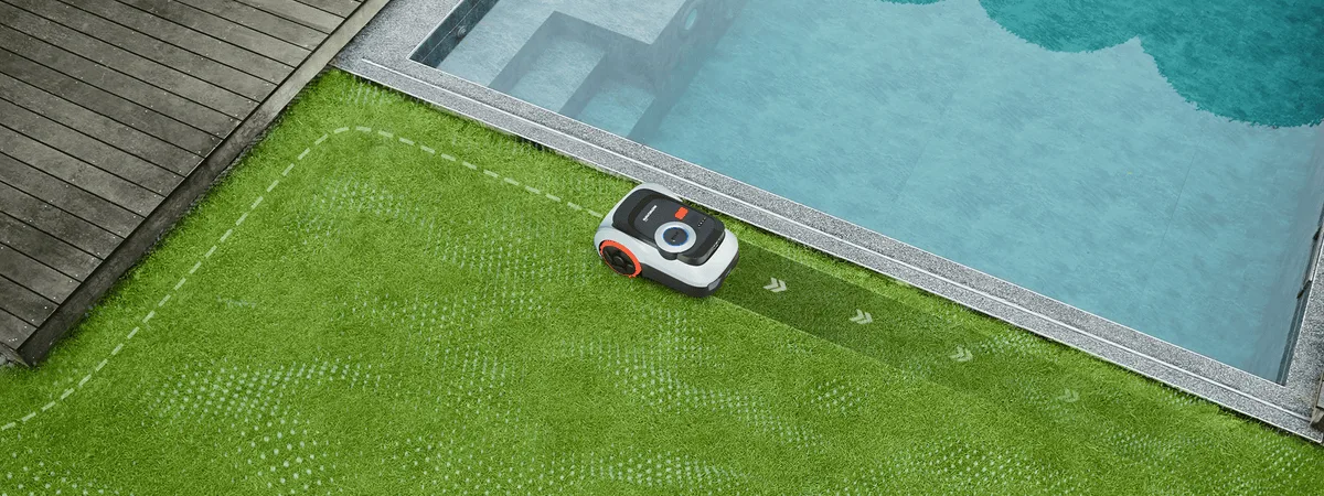 Segway Navimow i220 LiDAR Pro mentre taglia lungo un bordo del prato vicino alla piscina