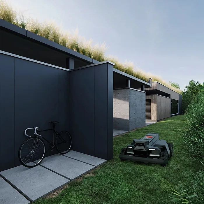 Segway Navimow X420 in azione lungo un corridoio erboso stretto accanto a una casa