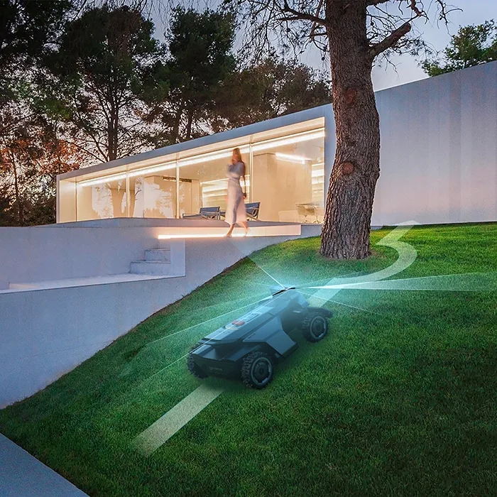Segway Navimow X420 su una pendenza davanti a un'architettura moderna